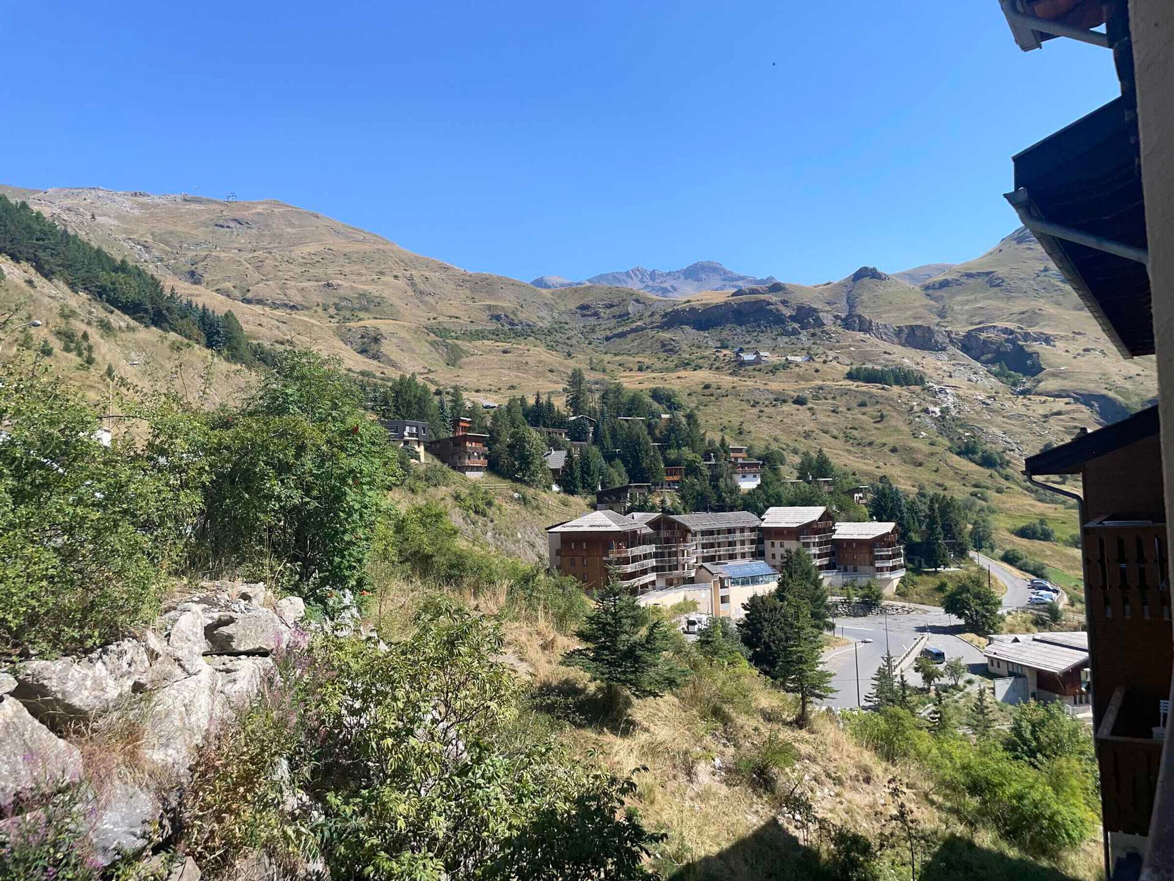 Ein Bergresort mit mehreren Gebäuden, darunter ein großes Hotel mit Balkonen, umgeben von felsigem Gelände und vereinzelter Vegetation.