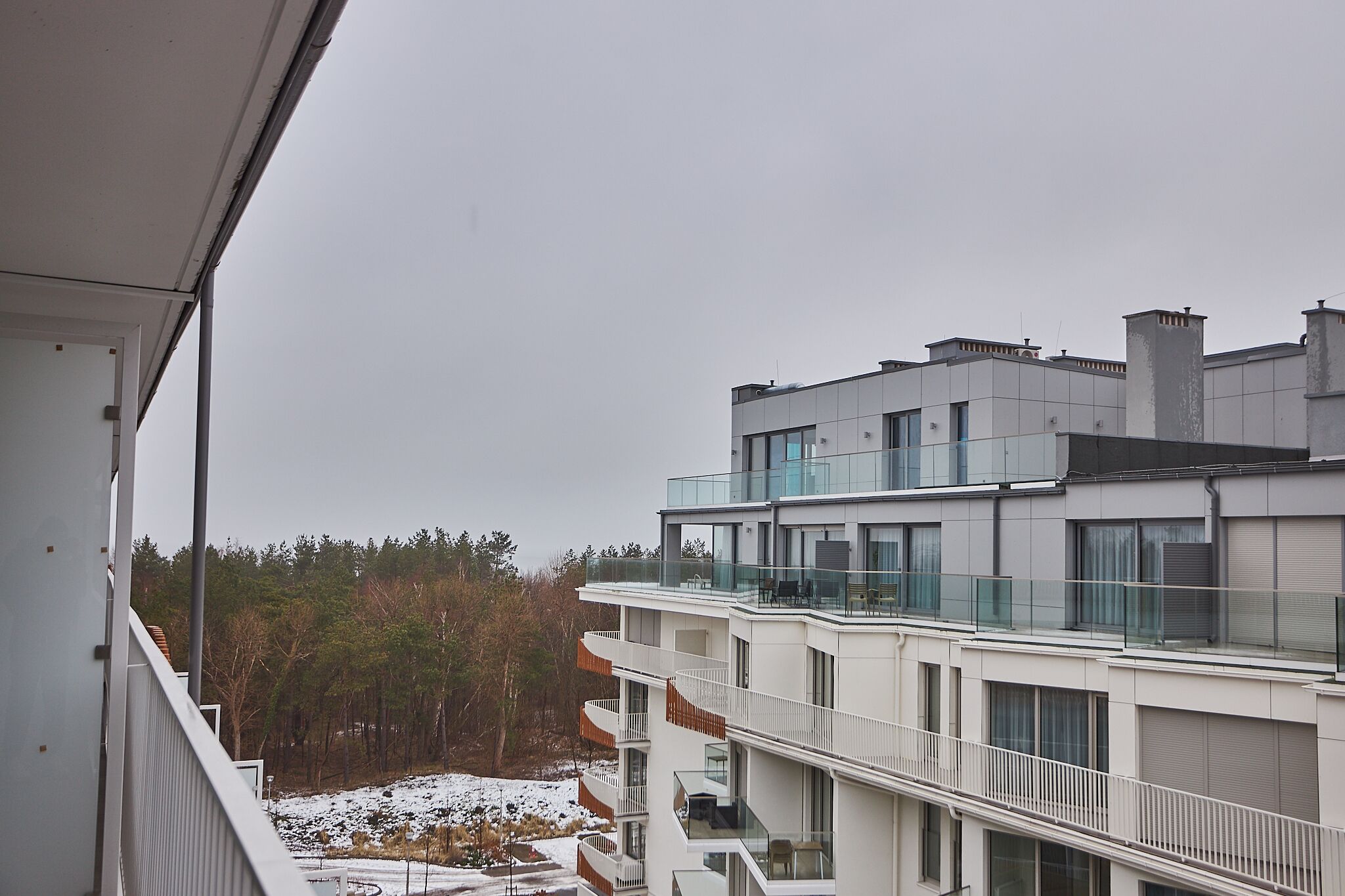 En modern byggnad med flera våningar, balkonger och stora fönster.