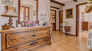 A spacious room with a wooden dresser, a large mirror, and a tiled floor. - Son Blai Petit by Rentallorca (Muro)