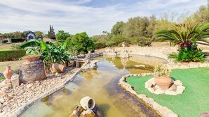 A garden with a pond, rocks, and various plants. - Son Blai Petit by Rentallorca (Muro)