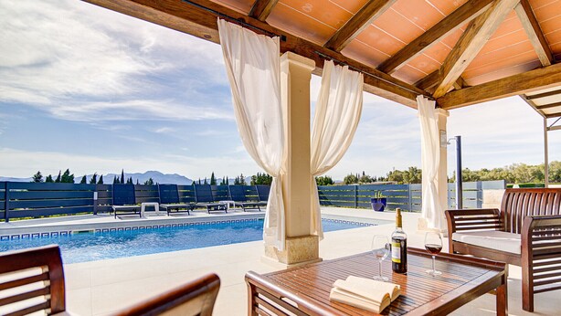 An outdoor pool area with wooden furniture and a view of mountains. - Son Blai Petit by Rentallorca (Muro)