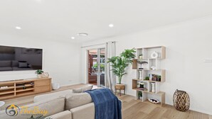 Un salon moderne avec un canapé, une table basse et une bibliothèque.
