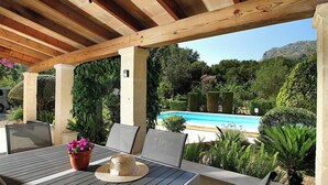 An outdoor patio with a wooden pergola, a pool, and lush greenery. - Finca Sant Jordi, private pool, quiet location with a view, A/C, Wi-Fi (IB)