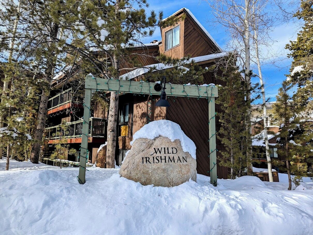A snow-covered outdoor area with a wooden structure and a sign that reads "WILD IRISHMAN".
