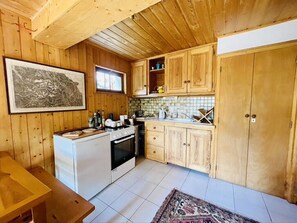A wooden-paneled kitchen with a refrigerator, stove, and cabinets. - Family Cottage With Garden In Saint Chaffrey (Saint-Chaffrey)