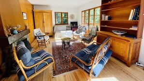 Una sala de estar acogedora con chimenea, muebles de madera y una estantería.