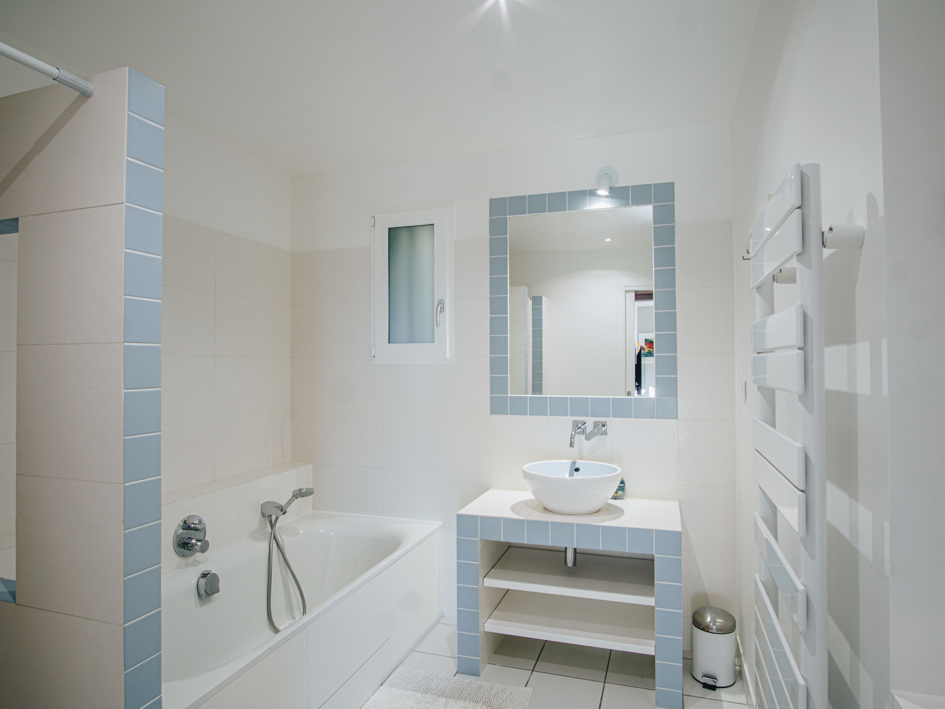 Een moderne badkamer met een bad, een wastafel en een spiegel.