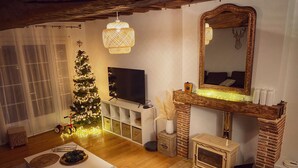 Ein gemütliches Wohnzimmer mit Kamin, einem großen Spiegel und einem Weihnachtsbaum.