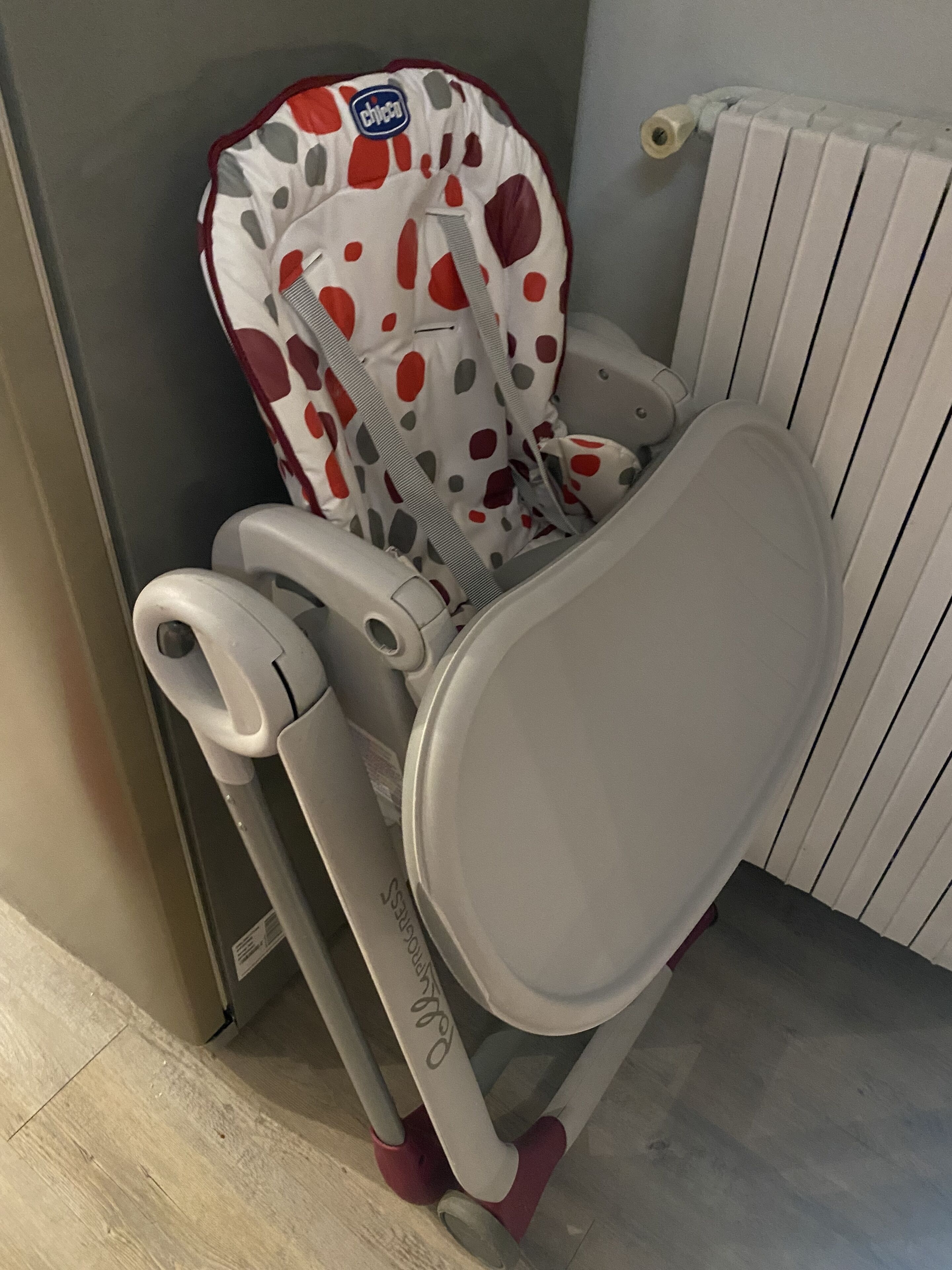 Un espace pour changer les bébés doté d’un matelas à motifs à pois, d’un repose-pieds et d’un compartiment de rangement.