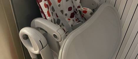 Un espace pour changer les bébés doté d’un matelas à motifs à pois, d’un repose-pieds et d’un compartiment de rangement.