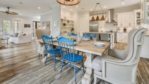 A spacious dining area with a wooden table, blue chairs, and a hanging light fixture. - Beautiful 2nd Row Beach Home w/ Beautiful Views (Hilton Head Island)