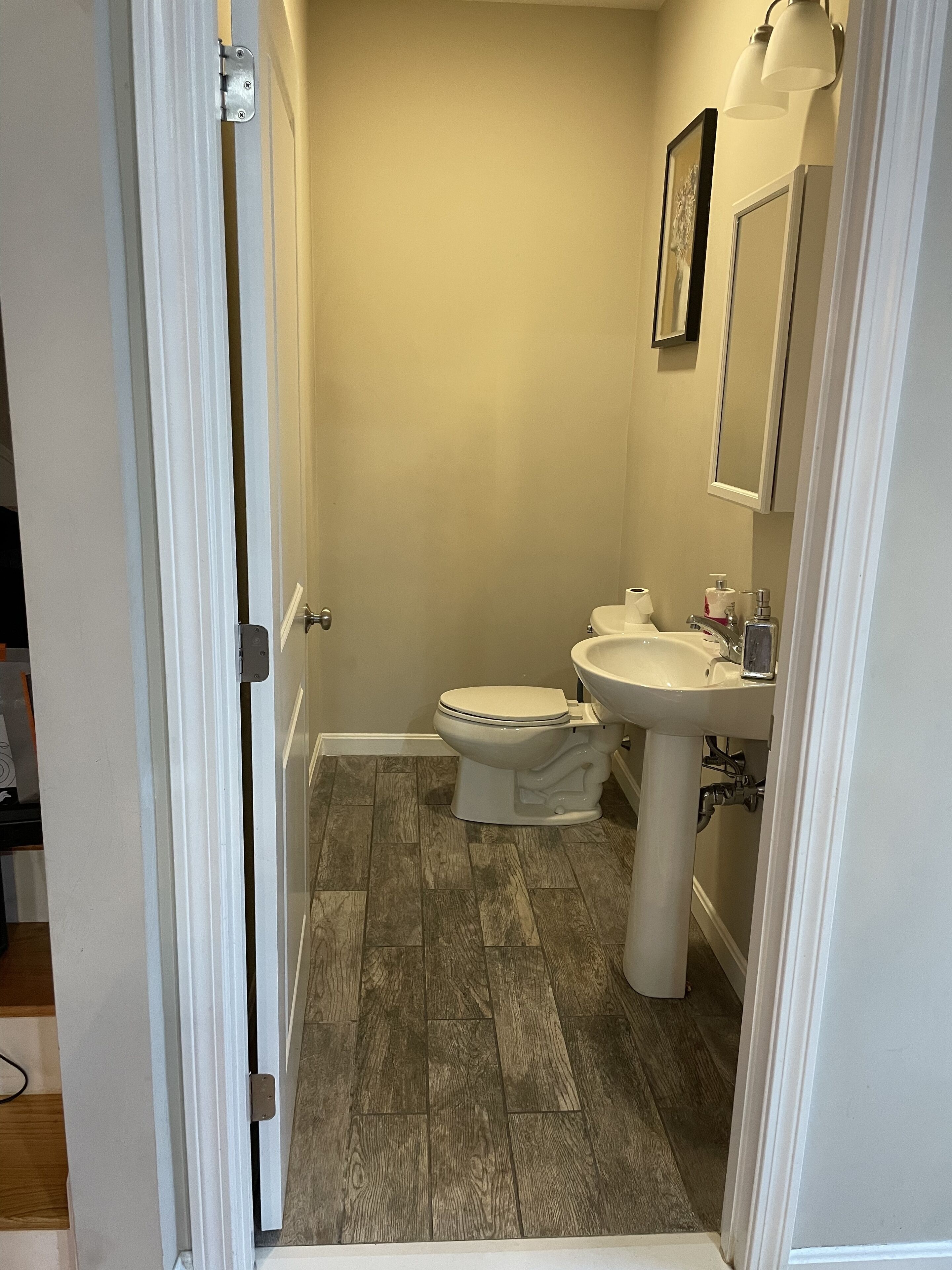 Een badkamer met toilet, wastafel en spiegel.