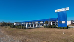 A Sunrise Inn motel with a blue exterior, multiple floors, and a prominent sign.