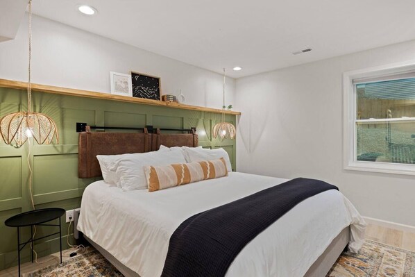 A bedroom with a bed, a nightstand, a window, and wall-mounted shelves. - Near Biltmore, Hiking, Breweries W/ Game Room (Fletcher)