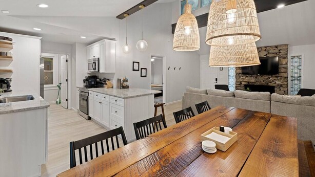 A modern kitchen with white cabinets, a central island, and pendant lighting.