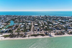 An aerial view of a coastal residential area with houses, a marina, and a beach. - La Cocolia located on north end of Ami. Lagoon Pool, Walk to Pine Ave. (Anna Maria)
