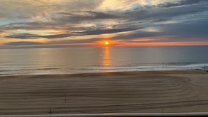 Una spiaggia al tramonto, mare calmo e cielo sereno.