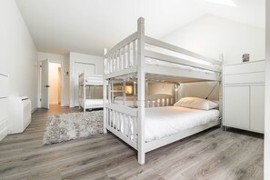 A bunk bed room with a white wardrobe and a fluffy rug.