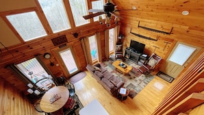 A cabin interior with a living room, dining area, and a fireplace. - Spectacular year-round views of Smokey Mountain National Park from a D-Log Cabin (Whittier)