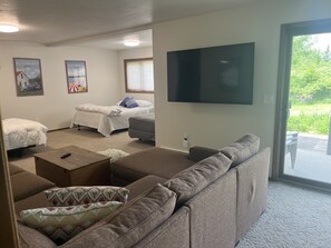 Una habitación con un sofá grande, dos camas, un televisor y un cartel de Ellison Bay.