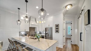 A modern kitchen with a large island, stainless steel appliances, and pendant lighting. - Escapeto30A/GolfCartIncluded/Pool/WalkToBeach (Santa Rosa Beach)