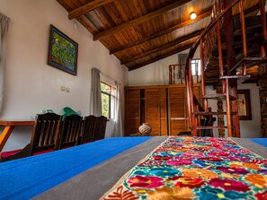 A room with a wooden ceiling, a colorful rug, a staircase, and a painting on the wall. - Hotel Boutique Finca de la Niebla Coatepec (Tlalnelhuayocan)