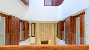 Ein modernes Interieur mit Glastrennwand, Holzverkleidung und Backsteinwand.