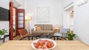 Una sala de estar con un sofá, dos sillones, una mesa de centro y un cuenco decorativo.