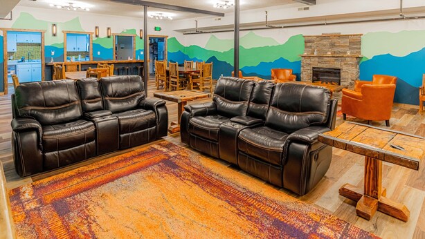 A spacious living area with leather sofas, a wooden coffee table, and a fireplace.