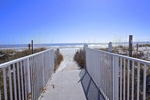 A pathway leading to a beach with a clear sky. - Beach Life Calling! "Toes in the Sand" 2 bed/2 bath beachfront condo (Orange Beach)
