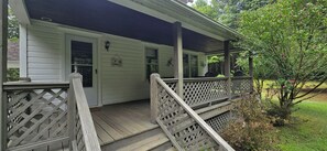 Uma casa de dois andares com varanda coberta e deck de madeira.