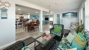 A spacious living area with a dining table, comfortable seating, and a kitchen in the background. - Island Tyme- Canal Waterfront Paradise with Sunset View! (Freeport)