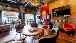 A cozy lounge area with leather seating, a billiards table, and a large screen TV.