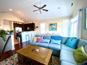 Relax in this inviting living space with a sofa, coffee table, and kitchen area.