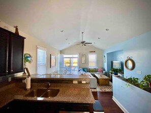 Relax in this inviting space with a sofa, chairs, and a small table, offering a view of the outdoor area.