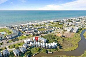Stunning waterfront homes line the shore, offering serene views of the ocean and surrounding green spaces.