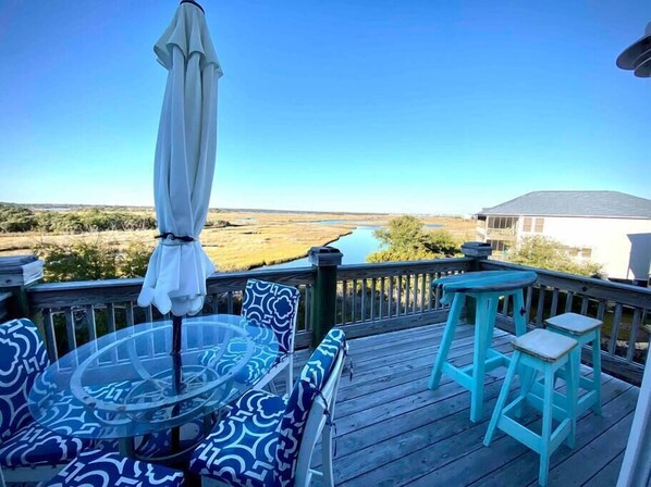 Relax on the deck with a glass-top table and comfortable seating, taking in the serene views of the surrounding landscape and water.
