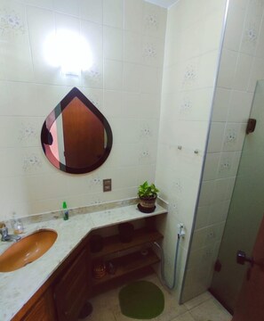 Chuveiro, toalhas de banho, sabonete, papel higiênico