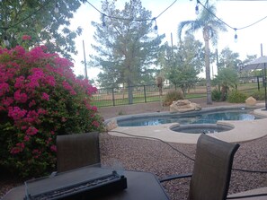 An outdoor patio with a pool, surrounded by a fence, chairs, and a table. - Serene Golf Course Suite with Private Bedroom, Bath + Heated Pool & Spa. (Mesa)