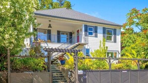 Une maison à deux étages dotée d’un porche et d’un escalier menant à l’étage supérieur.