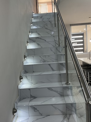 A staircase with marble steps and a metal handrail.