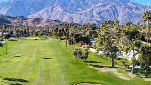 A golf course with a mountain backdrop, well-maintained grass, and palm trees. - Desert Retreat Relax, Recharge, Views, Resort Living, Office + Monthly Discount (Palm Springs)
