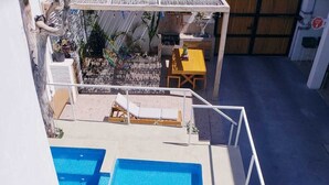 A rooftop pool with clear blue water, surrounded by a white railing and a wooden deck. - Casa Palo Verde, Standard bedroom 1 queen bed, Full Kitchen (Cabo San Lucas)