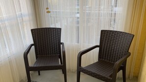 Två fåtöljer av rotting med flätad sits och ryggstöd, placerade på en matta med mönstrad yta.