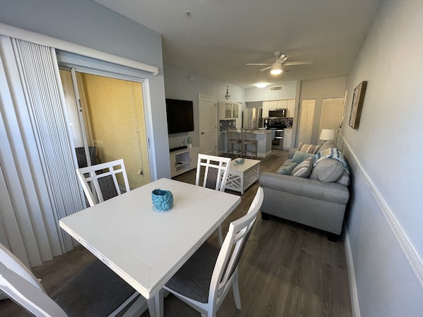 A compact living space with a dining area, a sofa, and a kitchenette.