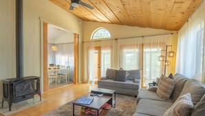 A spacious living room with a wooden ceiling, a sofa, a coffee table, and a fireplace. - 1Br Hidden Gem overlooking Wetland Dog Friendly (Flagstaff)