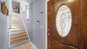 Een trap die leidt naar een kamer met een houten deur voorzien van een glas-in-loodraam.