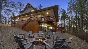 A two-story lodge with a fire pit and Adirondack chairs in the outdoor seating area. - 3 Masters, w/Bunk Room, Shuffle Board, Arcades, Hot Tub-Great For Families (Broken Bow)