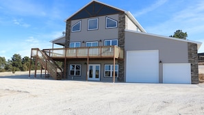 A two-story house with a balcony, a garage, and a driveway.