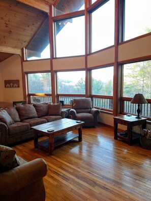 Relax in this inviting living room with a high ceiling and expansive views of the outdoors.